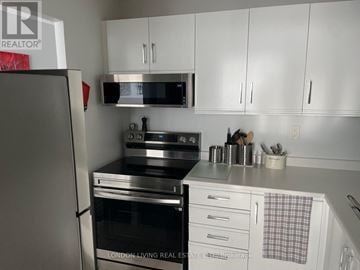 London South (South J) condo for rent - A kitchen with a stove top oven and a microwave above it.