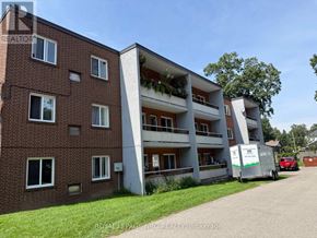 Niagara Falls (Dorchester) multi-family for rent - A red brick building with a white garage door and a white trailer parked in front.