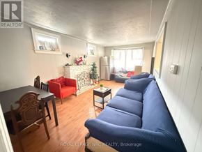 Niagara Falls (Hospital) apartment for rent - A living room with a blue couch and a table with chairs.