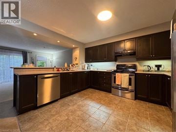 Kitchener townhouse for rent - A kitchen with dark wood cabinets and a tile floor.