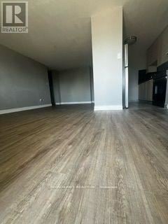 Toronto (Dorset Park) condo for rent - A large empty room with wooden flooring and a white door.