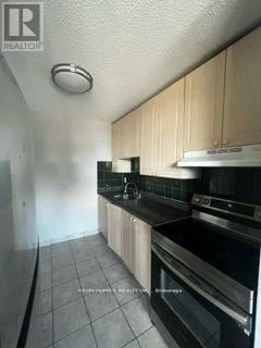 Toronto (Dorset Park) condo for rent - A kitchen with black appliances and white cabinets.