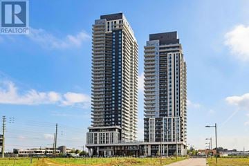 Vaughan (Vaughan Corporate Centre) condo for rent - Two tall buildings with balconies are under a blue sky.