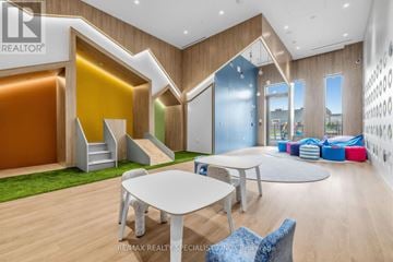 Vaughan (Vaughan Corporate Centre) condo for rent - A modern living room with a white table and blue chairs.