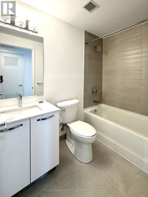 Hamilton (Corktown) condo for rent - A white toilet sits next to a sink in a bathroom.