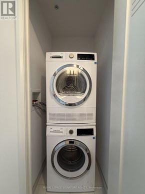 Hamilton (Corktown) condo for rent - A white dryer and washer stacked on top of each other in a small laundry room.