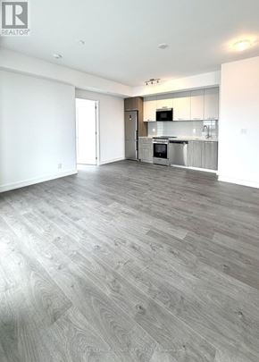Hamilton (Corktown) condo for rent - A spacious kitchen with a grey floor and white walls.