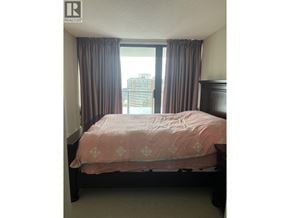 Burnaby apartment for rent - A bedroom with a bed, curtains, and a window.