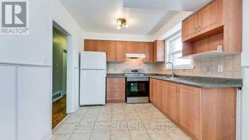 Toronto (Kennedy Park) apartment for rent - A kitchen with wooden cabinets and a white fridge.