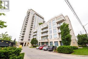 Toronto (Long Branch) condo for rent - A large apartment building with a parking lot in front.