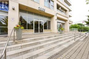 Toronto (Long Branch) condo for rent - A building with a glass door entrance and a no parking sign on the wall.