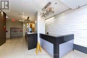 Toronto (Long Branch) condo for rent - A reception area with a black counter and a chandelier.