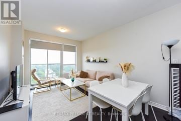 Toronto (Long Branch) condo for rent - A living room with a white couch and a television.