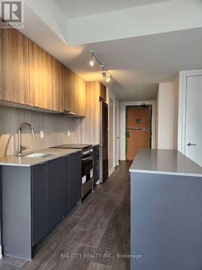 Toronto (Clanton Park) condo for rent - A kitchen with wooden cabinets and a grey counter.