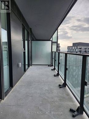 Toronto (Clanton Park) condo for rent - A balcony with glass railings and doors leading to an unknown destination.