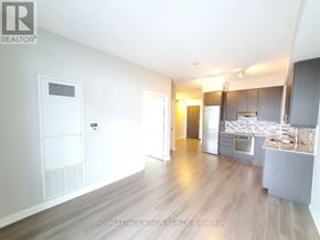 Toronto (Henry Farm) condo for rent - A spacious, well-lit room with a kitchen area in the background.