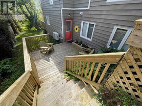 St. John's multi-family for rent - A wooden deck with a red door and a sunflower on the window sill.