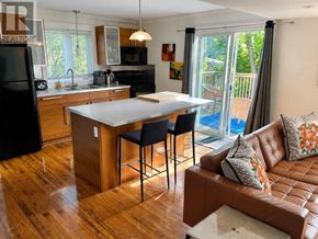 St. John's multi-family for rent - A kitchen with a table and chairs in the middle of the room.