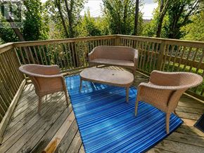 St. John's multi-family for rent - A wooden deck with a round table and two chairs.