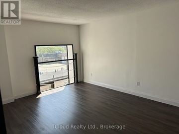 Hamilton (Dundas) multi-family for rent - A room with a sliding glass door leading to a parking lot.
