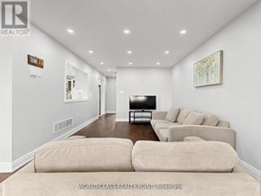 Oshawa (Samac) apartment for rent - A living room with a couch, a television, and a painting on the wall.