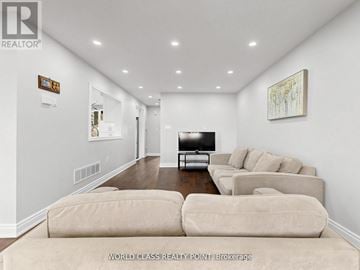 Oshawa (Samac) apartment for rent - A living room with a couch, a television, and a painting on the wall.