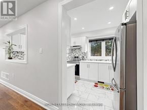 Oshawa (Samac) apartment for rent - A modern kitchen with white cabinets and a refrigerator.