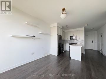 Richmond Hill (Langstaff) condo for rent - A spacious kitchen with white cabinets and a wooden ceiling light.