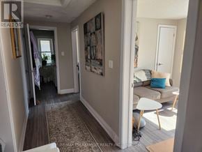St. Catharines (Downtown) triplex for rent - A hallway with a carpeted floor and a painting on the wall.
