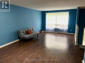St. Catharines (Oakdale) apartment for rent - A living room with a grey couch and a wooden floor.