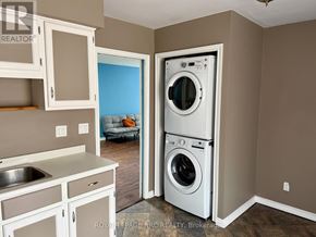 St. Catharines (Oakdale) apartment for rent - A small laundry room with a washer and dryer stacked on top of each other.