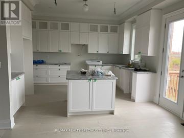 Richmond Hill apartment for rent - A kitchen with white cabinets and a large island in the middle.