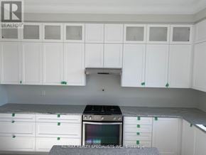Richmond Hill apartment for rent - A kitchen with white cabinets and a black oven.