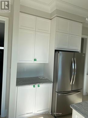 Richmond Hill apartment for rent - A kitchen with white cabinets and a stainless steel refrigerator.