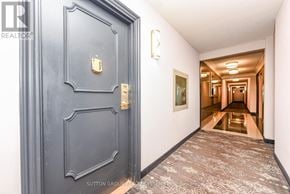 Burlington (Brant Hills) condo for rent - A hallway with a dark grey door and a carpeted floor.
