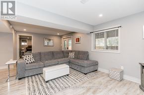 Barrie (Bayshore) apartment for rent - A living room with a grey couch and a white ottoman.