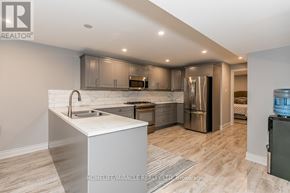 Barrie (Bayshore) apartment for rent - A modern kitchen with stainless steel appliances and a white island.
