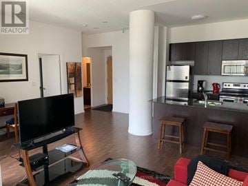 Toronto (Islington-City Centre West) condo for rent - A living room with a black television set on a wooden stand.