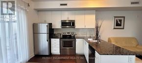 Toronto (Bathurst Manor) townhouse for rent - A kitchen with granite countertops and white cabinets.
