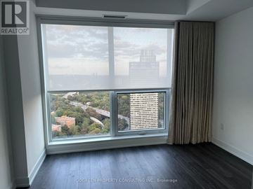 Toronto (North St. James Town) condo for rent - A room with a large window overlooking a cityscape.