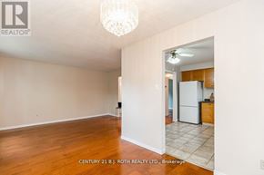 Barrie (Cundles East) apartment for rent - A room with a chandelier and a kitchen in the background.