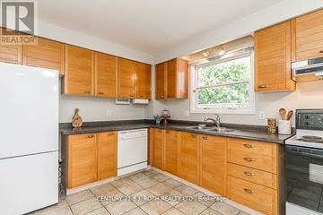 Barrie (Cundles East) apartment for rent - A kitchen with wooden cabinets and a white fridge.