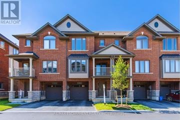 Hamilton (Stoney Creek Mountain) townhouse for rent - A large, multi-story brick building with a balcony on the second floor.