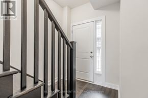 Hamilton (Stoney Creek Mountain) townhouse for rent - A hallway with a white door and a wooden staircase.