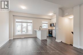 Hamilton (Stoney Creek Mountain) townhouse for rent - A well-lit, empty room with a kitchenette and a window.