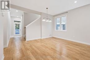 Ottawa townhouse for rent - A spacious room with wooden flooring and white walls.