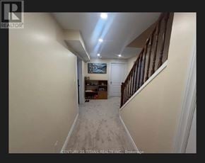 Toronto (Highland Creek) apartment for rent - A hallway with a wooden staircase and a painting on the wall.
