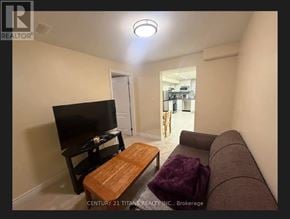 Toronto (Highland Creek) apartment for rent - A living room with a brown couch, a wooden coffee table, and a flat-screen TV.
