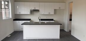 Wasaga Beach apartment for rent - A kitchen with white cabinets and a black countertop.
