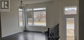 Wasaga Beach apartment for rent - A room with a black railing and a window overlooking a backyard.